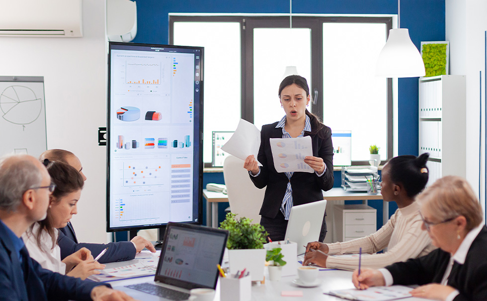 TOGAF® Standard-10th Edition-il nuovo punto di riferimento per l’Enterprise Architecture Professionista presenta grafici a un team durante una riunione di pianificazione strategica